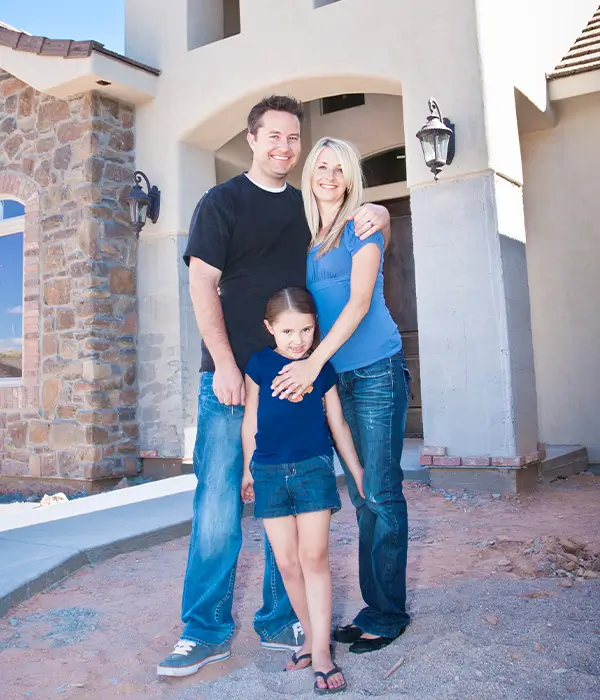 Family standing in front of home happy and smilling together